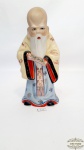 Escultura sabio chines em porcelana representando sabedoria.Medida 21,5 cm altura.