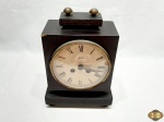 Antigo relógio de mesa alemão da marca Mauthe, com caixa de madeira nobre. Medindo 17cm x 10cm x 25cm de altura, acompanha a chave, necessita de revisão e possui um leve bicado na caixa.
