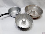 Lote de 2 formas de bolo e 1 escorredor de macarrão em alumínio. Medindo a forma maior 27,5cm de diâmetro de boca x 9,5cm de altura.