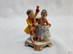 Bibelot, escultura em porcelana de casal com trajes de gala. Medindo 14,5cm de altura.