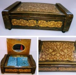 Antiga caixa de música porta-jóias Italiana ricamente marchetada com volutas e arabescos, interior estofado em cetim cor de azul claro no estado  ,  e espelho oval ,   med. 25 x 15 x 8 cm alt fechada , e aberta 19cm ,  Caixa de música funcionando .