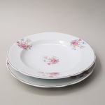 Par de pratos, sendo 1 rasos e um fundo, com decoração floral, de porcelana REAL. Medida aproximada: 24 cm de diâmetro.