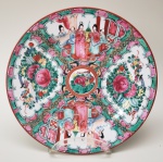 Prato de porcelana chinesa, com ornamentação em reservas de famílias chinesas, flores e pássaros. Medidas aproximadas: 26 cm de diâmetro.