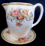 Antiga leiteira com motivos florais,possui prato para apoio, fabricado na Inglaterra. Medidas: 13,5 cm de comprimento X 14,5 cm de diâmetro (prato).  