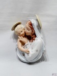 Imagem de Nossa Senhora com menino Jesus em porcelana com policromia. Medindo 18,5cm de altura. Possui perda do dedo.