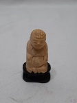 Escultura de Buda sentado em osso (marfim?) entalhado com peanha em madeira. Medindo 7cm de altura