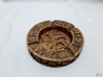 Cinzeiro ricamente trabalhado em pedra. Medindo 16,5cm de diâmetro x 3,5cm de altura. Com bicado na borda.