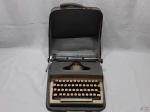 Antiga máquina de escrever Monarch Remington, no estojo.