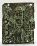 Antigo Reino do Benin, depois Daomé (c. 1600-1900), e desde 1975 República do Benin. Etnia Edo. Excepcional placa em bronze, com 4 furos para afixação, representando dois guerreiros conduzindo um prisioneiro. No que respeita à arte da África Negra, nada suplanta os bronzes produzidos no antigo Reino do Benin entre o Séc. XIII e 1897, quando cerca de mil deles, que adornavam as residências reais, foram apossados pela Inglaterra e hoje se encontram no British Museum. Cera perdida. Medidas: 20 x 15,5 cm. Peso: 1040 g.