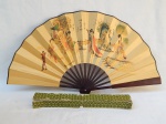 Leque em madeira e papel dourado japonês, aplicados com cenas de damas nobres japonesas. Comp. fechado 34cm.