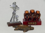 Três peças decorativas: a) Escultura dos 3 macacos sábios da cidade de Nikko, Japão. 9 x 9 x 5cm. b) Escultura de violinista em metal sobre base de madeira. 12 x 7 x 3cm. c) Cinzeiro em bronze na forma de tartaruga. 11 x 7cm.