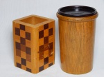 Duas peças em madeira: a) Porta-canetas em cerejeira marchetada com decoração xandrez. 11 x 8 x 8cm. b) Cofre na forma de copo em cerejeira, tampa em jacarandá. Trabalho artesanal. 14 x 10cm.