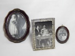 Três porta-retratos: a) Dois com moldura oval em resina, decorados com aplicações de folhagens, 18 x 14cm e 10 x 7cm. b) Um com moldura em metal aplicado com pedrinhas plásticas. 16 x 11cm.