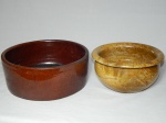 Dois cachepots, sendo um marrom em cerâmica canelada e um em pedra-sabão bege marrom, com pequenas marcas do tempo. 11 x 21cm e 13 x 21cm.
