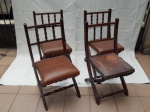 Quatro cadeiras estilo rústico em madeira nobre, assento recolhível, pernas em "x", assento em couro sintético decorado com tachões. Algumas no estado. 85 x 50 x 50cm.