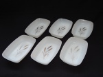 Seis petisqueiras em vidro leitoso branco dito "milk glass", decoradas com folhas de trigo ao fundo. Manufatura ARCOPAL, França. Anos 60. Decoração com desgastes e manchas. 3 x 18 x 11,5cm.