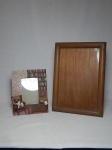 Dois porta-retratos: 1 com moldura em resina policromada feita na forma de biblioteca com cachorro; e 1 com moldura em madeira lisa. 24 x 18cm e 35 x 26cm.