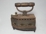 Ferro de passar antigo, acompanha por suporte de base. Apresenta oxidação. 24 x 18 x 9cm.