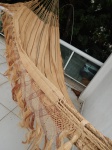Rede artesanal indígena confeccionada em palha trançada e trabalhada. Comp. 3,30m. Apresenta manchas.
