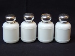 Quatro frascos vazios do perfume Anais Anais, da Cacharel, confeccionados em vidro leitoso branco, tampa em metal. Alt. 9cm.