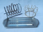 Três peças em metal: 2 porta-torradas e 1 porta-rocambole. 11 x 13 x 8cm, 7 x 12cm e 25 x 10cm.