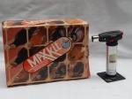 Duas peças utilitárias: a) Garrafeira modular Maxkit em plástico, peças montáveis. Na caixa com manual. Acompanha peças sobressalentes para montagem. Montada 34 x 34 x 24cm. b) Maçarico para cozinha, manufatura alemã Küchenprofi. Na caixa original. Incompleto, faltando tigelas do kit. Funcionando, porém sem garantias. Alt. 17cm.