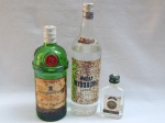Três garrafas de bebidas importadas: a) Gin inglês Tanqueray, 1L. Lacrado porém com evaporação. b) Vodka polonesa Wyborowa, 1L, rótulo no estado. Lacrada. c) Vodka miniatura Zabrowka, 100mL, lacrada.