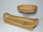 Duas cestas em vime trançado, sendo uma oval 6 x 29 x 22cm e uma retangular com alças altas, 12 x 48 x 20cm. Trabalhos artesanais.