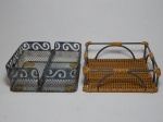 Conjunto de 2 porta-guardanapos em ferro fundido, um decorado com vime trançado, 6 x 18 x 18cm; e um decorado com grade vazada, galeria com volutas vazadas, haste-peso para prender os guardanapos. 7 x 18 x 18cm.