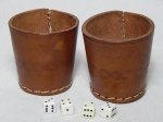 Conjunto para gamão constando de 6 peças: dois copos de couro costurado à mão, 8 x 7cm; e 4 dados em resina branca com números pretos.