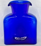 Garrafa para água em vidro transparente na cor azul real, borda com 2 bicos. Alt. 20cm.