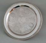 Linda Bandeja redonda de metal espessurado a prata, com decoração central e na borda. Possui 38,5 cm de diâmetro 