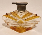 Lindo Perfumeiro de vidro transparente e âmbar, em forma de losango, com tampa também de metal e acionador de borrifador. Mede 12 x 12 x 8 cm
