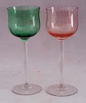 Par de taças de cristal. Uma em tom verde e a outra em tom rosa. Medem 19 cm de altura