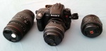 Câmera fotográfica SONY ALPHA 580 com três lentes: Sony 18-55mm 3.5-5.6 SAM, Sony 50mm 1.8 SAM, Sigma 70-300mm 4-5.6; cartão SD 8 GB, carregador, bateria e cases para a câmera e lentes
