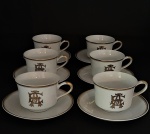 Conjunto contendo 06 xícaras de chá em porcelana de manufatura nacional na tonalidade branca, monograma com as iniciais EA ( Estanislau do Amaral) em ouro. Brasil. Séc. XX.