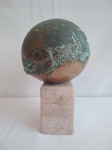 Escultura em bronze fixada em vaso de mármore, representando um planeta, medindo 26cm de altura, incluindo a base.