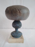 Escultura em cerâmica, representando um cogumelo, com base de acrílico, medindo 19cm de altura, incluindo a base.