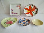 Cinco pratos de porcelana, pintados a mão, com motivos florais, medindo o maior 18cm de diâmetro e o menor 10cm de diâmetro.