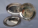 Três peças em metal com banho de prata, marca Fracalanza, sendo dois pratos redondos, medindo 37cm de diâmetro, e uma travessa oval, medindo 47x30cm.