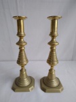 Dois castiçais em metal dourado, medindo o maior 17,5cm de altura.