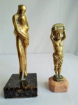 Duas estatuetas em bronze, com base em mármore, sendo uma representando Madona com criança, medindo 17cm de altura, e a outra representando homem romano, medindo 13.5cm de altura.