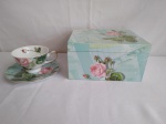 Xícara para chá, decorada com flores, acondicionada em uma bela caixa, com a mesma decoração.