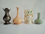 Quatro vasos, de modelos e materiais diversos, sendo um de estanho, medindo 12cm de altura, um de opalina, no tom de rosa, medindo 13cm de altura, um em porcelana oriental, medindo 9cm de altura, e um no estilo vaso floreira, medindo 11cm de altura.