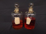 Dois perfumeiros de vidro com tampa em formato de bola, medindo 24cm de altura.( Não garantimos a integridade do conteúdo).