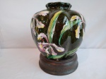 Vaso em porcelana na cor verde, com figura de orquídeas, em formato de moringa, medindo 8cm de diâmetro e 19cm de altura.