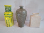 Três vasos em modelos, tamanhos e materiais diversos, medindo o maior, na cor amarelo/verde, 6cm de diâmetro e 21cm de altura, e o menor, craquelado, com a boca 7x4cm e 14cm de altura.