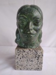 Escultura em ferro representando cabeça de mulher em pedra mármore rajada, alt: 27cm e base 12 x 12cm.