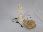 TRES itens religiosos, sendo a imagem de Santa Teresinha em resina, pequeno terço e medalha de santa Terezinha fixada em peça de madeira moldada.