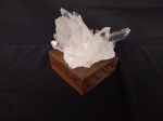 Druzia de cristal branco, em formato de ponta, com base em madeira. Peso 870 gramas.